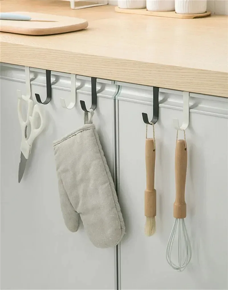 Crochet polyvalent fixé à une porte d'armoire de cuisine