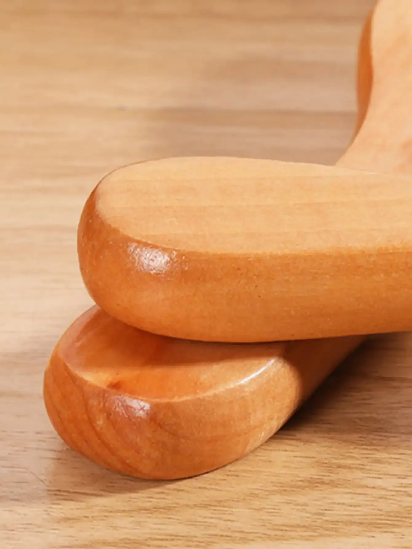 Rouleau masseur en bois en utilisation sur les jambes