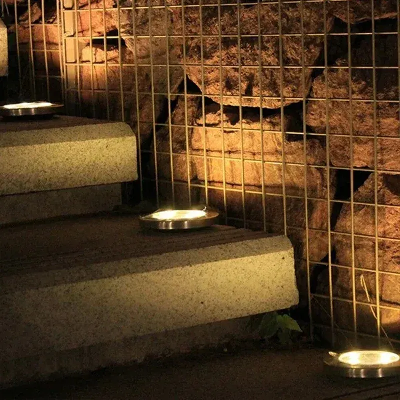 Lumières solaires enterrées éclairant un jardin en soirée
