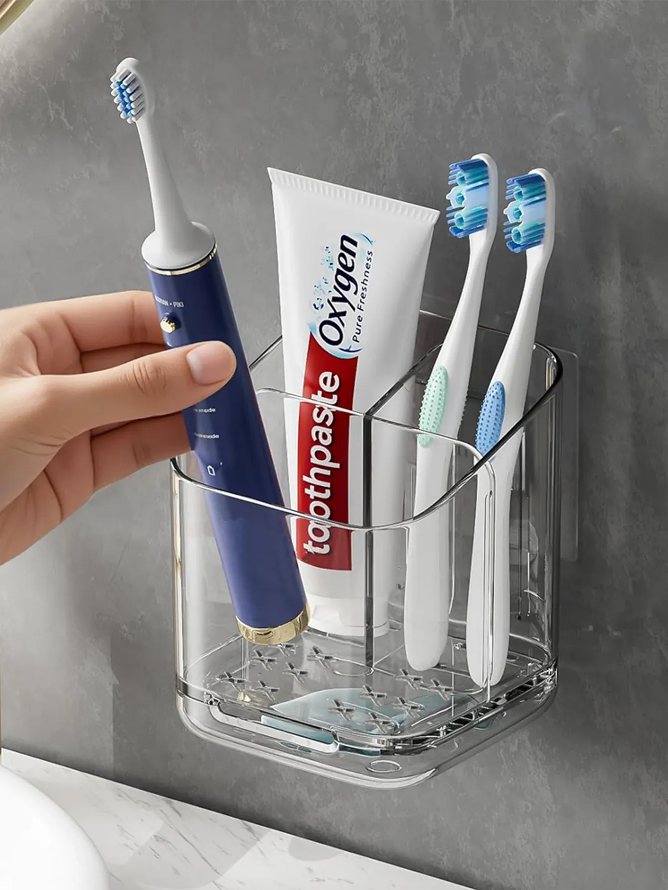 Support mural transparent pour brosses à dents installé dans une salle de bain