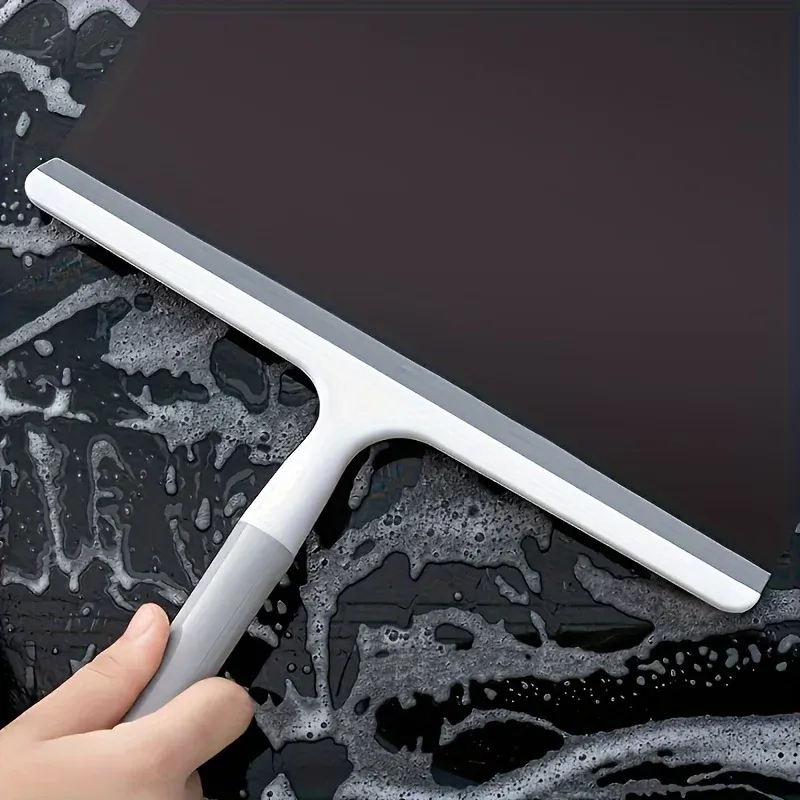 Raclette de douche en silicone sur une surface carrelée