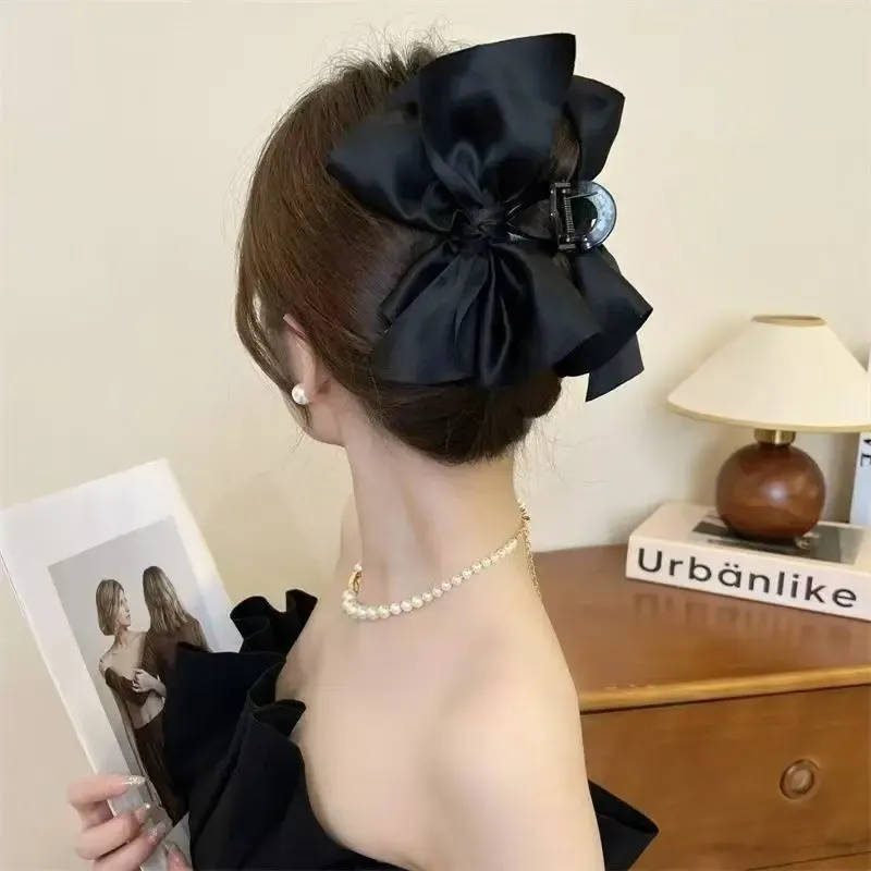 Pince à cheveux noire en forme de nœud, finition soignée
